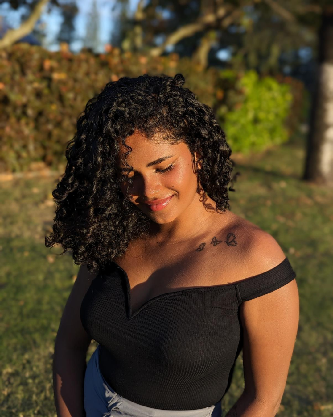 Jana smiling in the sun after stepping out of the shadows